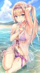 adjusting_hair arm_up armpits beach bikini blonde_hair blue_eyes blush breasts cloud commentary day flower granblue_fantasy hair_flower hair_ornament highres jeanne_d'arc_(granblue_fantasy) large_breasts long_hair looking_at_viewer mokyu mountain mouth_hold navel partially_submerged purple_bikini sandals side-tie_bikini side_ponytail smile solo swimsuit water 