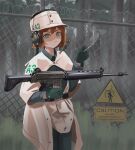  1girl absurdres ar-18 assault_rifle barbed_wire belt black_belt bob_cut breasts cape chain-link_fence cigarette clothes_writing commentary english_commentary english_text fence field_cap flipped_hair fog forest frown gloves grass green_eyes green_gloves green_jacket green_pants gun hair_between_eyes hand_up headphones headphones_over_headwear headset highres holding holding_cigarette holding_gun holding_weapon jacket klottinen light_frown looking_at_viewer microphone military_uniform nature original pants poncho red_hair rifle shaded_face short_hair sign small_breasts smoke smoking solo tall_grass tree uniform warning_sign weapon white_cape 