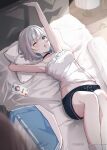  1girl 1other absurdres arata_ryou arm_behind_head arm_up artist_name bed black_choker blue_eyes blue_shorts blurry blurry_foreground breasts camisole cellphone choker commentary_request desk_lamp drawer fang feet_out_of_frame frilled_camisole frills from_above grey_hair highres indoors jacket kaga_nazuna kaga_sumire knees_up lamp legs_together looking_at_viewer lying medium_breasts midriff on_back on_bed one_eye_closed open_mouth phone picture_frame pillow short_hair shorts skin_fang smartphone socks solo stretching unworn_jacket virtual_youtuber vspo! white_camisole white_jacket white_socks 