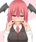  black_vest breasts commentary covered_mouth demon_wings eyebrows_visible_through_hair garasuita hair_between_eyes hands_up head_wings holding koakuma large_breasts long_hair long_sleeves looking_at_viewer necktie pink_background popsicle_stick red_eyes red_hair red_neckwear shirt solo touhou translated two-tone_background upper_body vest white_background white_shirt wing_collar wings 