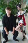  1boy 1girl ahri black_hair blue_eyes boots cleavage cosplay costume dress earring fox_ears height_difference high_heels identity_censor league_of_legends long_hair long_nails looking_at_viewer makeup nail_polish petite standing tail 