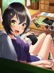  1girl blurry blurry_background controller eyebrows_visible_through_hair fang from_behind game_controller gamepad glass hair_ornament hairclip holding_hands kyon_(fuuran) looking_at_viewer looking_back open_mouth original remote_control shirt short_hair shorts sitting t-shirt yellow_eyes 