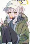  1girl baseball_cap black_pantyhose blue_archive blush commentary dot_nose food food_in_mouth green_eyes green_halo green_jacket grey_hair halo hare_(blue_archive) hare_(camp)_(blue_archive) hat highres jacket knees_up long_hair looking_at_viewer morita_(pixiv31883607) mouth_hold official_alternate_costume pantyhose ponytail roasted_sweet_potato solo sweet_potato v white_headwear 