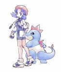  1girl bike_shorts blue_eyes blue_hair closed_mouth croconaw cropped_jacket hat highres holding holding_poke_ball holding_strap jacket kneepits kris_(pokemon) long_hair open_clothes open_jacket pink_hat poke_ball pokegear pokemon pokemon_(creature) pokemon_gsc shirt shoes smile standing tan_carbonnn twintails white_background white_shoes 
