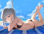  ass barefoot beach bikini black_bikini blanket blue_eyes blue_sky blush breasts closed_mouth commentary_request day eyebrows_visible_through_hair feet_up grey_hair hair_between_eyes inushi kantai_collection kashima_(kantai_collection) looking_at_viewer lying medium_breasts ocean on_stomach outdoors sky smile soles solo swimsuit thong_bikini 