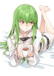  bangs barefoot c.c. code_geass creayus cup eyebrows_visible_through_hair green_hair holding holding_cup hood hoodie legs_up long_hair looking_away lying on_stomach parted_lips solo straight_hair straitjacket yellow_eyes 