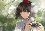  bangs black_hair black_neckwear black_ribbon branch brown_eyes camera commentary eyebrows_visible_through_hair hat highres holding holding_camera leaf looking_to_the_side neck_ribbon parted_lips pointy_ears pom_pom_(clothes) puffy_short_sleeves puffy_sleeves ribbon shameimaru_aya shirt short_hair short_sleeves solo thkani tokin_hat touhou upper_body white_shirt wing_collar 