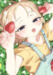  1girl blonde_hair blue_eyes blush bouen clover denim flower food fruit highres holding holding_food holding_fruit looking_at_viewer lying on_back open_mouth orange_shirt original overalls shirt short_hair short_sleeves solo strawberry upper_body white_flower 