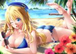  1girl absurdres ass atago_(kantai_collection) ayakase_hotaru beach beret bikini blonde_hair blue_bikini blue_eyes blue_headwear blue_sky boat breasts building collarbone day eyebrows_visible_through_hair flower hat heart heart_necklace highres holding holding_eyewear jewelry kantai_collection large_breasts legs_up long_hair looking_at_viewer lying necklace ocean on_stomach one_eye_closed open_mouth outdoors palm_tree purple_flower red_flower sand shore side-tie_bikini sky smile solo sunglasses swimsuit tree untied untied_bikini watercraft yellow_flower 