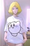  1girl adjusting_clothes blonde_hair blue_eyes blush character_name character_print commentary english_text gundam highres indoors kirby kirby_(series) mobile_suit_gundam moroboshi_danshaku no_pants parted_bangs parted_lips print_shirt sayla_mass shirt short_hair signature smile solo standing watermark white_shirt 