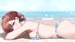  1girl ass bikini blurry blurry_background blush bokeh braid braided_bangs breasts brown_hair closed_mouth commentary_request depth_of_field earrings floral_print_bikini highres higuchi_madoka horizon idolmaster idolmaster_shiny_colors jewelry looking_at_viewer lying medium_breasts mole mole_under_eye nonbire o-ring o-ring_bikini o-ring_top ocean on_stomach outdoors purple_eyes short_hair smile solo swimsuit 