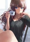  1girl :3 bangs black_shirt blue_eyes breasts brown_hair cleavage coffee commentary cup day hand_to_own_mouth hands_up highres holding holding_cup ichinose_shiki idolmaster idolmaster_cinderella_girls indoors long_hair looking_at_viewer looking_to_the_side medium_breasts mossi no_pants on_chair pinky_out shirt sitting solo t-shirt wavy_hair 