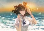  1girl blue_ribbon brown_eyes brown_hair flower fly_(marguerite) hands_up looking_at_viewer ocean original outdoors ribbon shirt short_sleeves solo standing twilight upper_body white_shirt wristband 