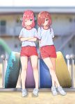  2girls ;( arms_behind_back blue_eyes blurry blurry_background blush closed_mouth commentary_request crossed_arms crossed_legs full_body go-toubun_no_hanayome gym_shorts gym_uniform hair_over_one_eye hair_ribbon highres kongbai looking_at_viewer medium_hair multiple_girls nakano_miku nakano_nino no_socks outdoors pink_hair red_shorts ribbon shirt shoes short_sleeves shorts siblings sisters smile standing t-shirt tire v-shaped_eyebrows white_footwear white_shirt younger 
