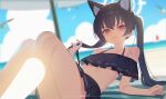  1girl animal_ear_fluff animal_ears bare_shoulders beach beach_mat beach_umbrella benpao_de_ruoji bikini bikini_skirt black_bikini black_hair blue_archive blurry blurry_background blush breasts cat_ears closed_mouth commentary extra_ears frilled_bikini frills furrowed_brow halo hand_in_own_hair highres knees_up long_hair looking_at_viewer ocean off-shoulder_bikini off_shoulder official_alternate_costume red_eyes serika_(blue_archive) serika_(swimsuit)_(blue_archive) small_breasts solo swimsuit twintails umbrella white_halo 