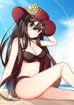  1girl absurdres bare_shoulders beach bikini black_hair blush breasts cleavage commentary_request day fate/grand_order fate_(series) from_below hat highres large_breasts long_hair looking_at_viewer navel oda_nobunaga_(fate)_(all) oda_nobunaga_(swimsuit_berserker)_(fate) oguri_(pixiv25574366) outdoors peaked_cap red_eyes sitting smile solo swimsuit water 