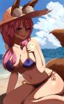  1girl absurdres animal_ear_fluff animal_ears artist_request beach bikini blue_bikini blush breasts cleavage collarbone commentary commentary_request ears_through_headwear eyebrows_visible_through_hair fang fate/grand_order fate_(series) fox_ears fox_girl fox_tail hat highres large_breasts looking_at_viewer navel ocean open_mouth outdoors pink_hair side-tie_bikini sitting skin_fang solo straw_hat swimsuit tail tamamo_(fate)_(all) tamamo_no_mae_(swimsuit_lancer)_(fate) 