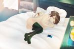  1girl absurdres bed bedroom bookshelf brown_hair casual cat chilledcow_stream_girl chilledcow_study_girl headphones highres lamp listening_to_music phone rainywins short_ponytail sleeping solo_focus study_girl 