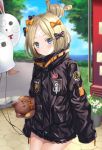  1girl abigail_williams_(fate/grand_order) bandaid_on_forehead bangs black_bow black_jacket blonde_hair blue_eyes blush bow closed_mouth commentary_request crossed_bandaids fate/grand_order fate_(series) forehead hair_bow hair_bun harimoji heroic_spirit_traveling_outfit high_collar holding_balloon jacket long_hair long_sleeves looking_at_viewer multiple_bows orange_belt orange_bow park parted_bangs polka_dot polka_dot_bow sleeves_past_fingers sleeves_past_wrists solo stuffed_animal stuffed_toy teddy_bear tree 