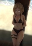  1girl absurdres bangs beach bikini black_bikini blonde_hair blush breasts brown_eyes cleavage closed_mouth commentary_request day expressionless girls_frontline highres looking_away mp40_(girls_frontline) navel ocean shadow shore short_hair solo standing sweat swimsuit tan tanline thighs triangle_bullet water 