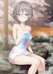  1girl anastasia_(idolmaster) bangs bare_arms bare_legs bare_shoulders blue_eyes blush breasts bush cherry_blossoms cleavage collarbone column eyebrows_visible_through_hair fence floral_print grey_hair hair_between_eyes idolmaster idolmaster_cinderella_girls looking_at_viewer medium_breasts naked_towel night onsen outdoors petals pillar rum_raisin_(chihiromakita19) short_hair sitting smile solo steam stone_floor towel water wet wet_hair 