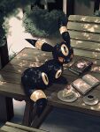  book book_stack cake cake_slice commentary cup dappled_sunlight day food fork full_body highres kuchiba_(jret2454) lying no_humans on_table open_book outdoors picnic_table plate pokemon pokemon_(creature) saucer signature solo strawberry_cake sunlight table umbreon 