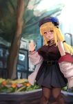  1girl bare_shoulders belt beret black_shirt blonde_hair blue_flower blue_headwear blue_rose blue_skirt blurry blurry_background blush breasts choker eyebrows_visible_through_hair flower gem hair_ribbon hand_up hat highres hose jacket jewelry kurusemina large_breasts long_hair looking_at_viewer nail_art open_clothes open_jacket open_mouth original oversized_clothes ribbon rose shirt skirt solo thighhighs tied_hair tongue tree waving white_jacket yellow_eyes 
