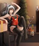  1girl animal_ears arknights arm_up bandeau bangs bare_arms bare_shoulders black_legwear black_shorts blurry blurry_background box breasts brown_eyes cat_ears ceylon_(arknights) chair character_doll christmas_tree commentary_request feet_out_of_frame garter_straps gift gift_box hair_between_eyes highres indoors long_hair medium_breasts micro_shorts no_shoes schwarz_(arknights) shorts silver_hair sitting solo strapless thighhighs thighs tubetop zhi_wozi 