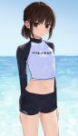  1girl black_shorts breasts brown_eyes brown_hair crop_top day highres long_hair looking_at_viewer midriff navel ocean original outdoors parted_lips raglan_sleeves shirt short_shorts shorts sidelocks small_breasts solo stomach swimsuit thighs tied_hair zuima 