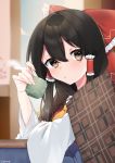  1girl abe_suke absurdres bangs black_hair blanket blush bow brown_eyes cup frilled_bow frills hair_between_eyes hair_bow hakurei_reimu highres holding holding_cup indoors kotatsu long_hair long_sleeves looking_at_viewer parted_lips plaid red_bow signature solo steam table touhou under_covers upper_body wide_sleeves 