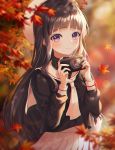  1girl autumn autumn_leaves bangs black_shirt blunt_bangs blurry blurry_foreground blush brown_hair camera cardcaptor_sakura closed_mouth commentary_request daidouji_tomoyo depth_of_field eyebrows_visible_through_hair falling_leaves floating_hair hands_up heeri holding holding_camera leaf long_hair long_sleeves looking_at_viewer maple_leaf neckerchief outdoors pleated_skirt purple_eyes sailor_collar shirt skirt smile solo white_headwear 