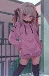  1girl :/ black_legwear black_mask black_ribbon blush building drawstring eyebrows_visible_through_hair feet_out_of_frame grey_hair hair_ribbon hands_on_hips highres hood hoodie hoodie_dress looking_at_viewer makaino_ririmu mask_pull multicolored_hair nijisanji pink_hair pink_hoodie pointy_ears railing red_eyes ribbon sabamen sidelocks solo thighhighs twintails two-tone_hair virtual_youtuber 