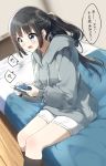  1girl bangs black_hair black_legwear blue_eyes blurry blurry_background blush commentary_request controller depth_of_field drawstring eyebrows_visible_through_hair game_controller grey_hoodie holding hood hood_down hoodie indoors kneehighs long_hair long_sleeves looking_away on_bed open_mouth original pentagon_(railgun_ky1206) ponytail puffy_long_sleeves puffy_sleeves ribbed_legwear short_shorts shorts sidelocks sitting sitting_on_bed sleeves_past_wrists solo translation_request v-shaped_eyebrows very_long_hair white_shorts wooden_floor 