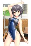  1girl absurdres bangs beach_umbrella bench black_hair blue_swimsuit blurry braid brown_eyes chair competition_swimsuit cowboy_shot depth_of_field fence girls_und_panzer grin highres looking_at_viewer one-piece_swimsuit pepperoni_(girls_und_panzer) short_hair side_braid smile solo swimsuit takafumi two-tone_background umbrella 