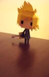  1boy artist_request black_coat_(kingdom_hearts) black_pants blonde_hair blurry chibi chinese_commentary commentary_request depth_of_field english_commentary expressionless full-length_zipper full_body holding holding_weapon illbewaiting keyblade kingdom_hearts kingdom_hearts_ii long_sleeves male_focus mixed-language_commentary on_table pants papercraft_(medium) photo_(medium) roxas short_hair solid_oval_eyes solo spiked_hair table unconventional_media weapon wide_sleeves yellow_background zipper 