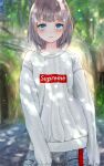  1girl bangs blue_eyes blush denim eyebrows_visible_through_hair forest grey_hair highres jeans leaning_to_the_side looking_at_viewer medium_hair nature ni$hi-xxxx open_mouth original pants parted_lips sleeves_past_wrists solo supreme sweater white_sweater 