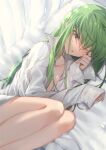  1girl bed_sheet breasts c.c. code_geass commentary_request creayus eyebrows_visible_through_hair green_hair legs long_hair long_sleeves looking_at_viewer lying on_side one_eye_closed open_clothes open_shirt pillow shirt small_breasts solo white_shirt yellow_eyes 