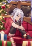  1girl akkijin ass bell blue_eyes box braid cape christmas christmas_tree couch gift gift_box grey_hair indoors lonely looking_at_viewer no_shoes official_art red_cape sad shinkai_no_valkyrie sitting snowing sweater thighhighs window 