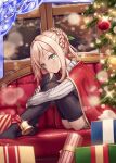  1girl akkijin ass bell blonde_hair box braid cape christmas christmas_tree couch gift gift_box green_eyes hair_ornament indoors lonely looking_at_viewer no_shoes official_art red_cape sad shinkai_no_valkyrie sitting snowing sweater thighhighs window 