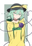  1girl absurdres alternate_costume bangs black_headwear border clothes_writing contemporary drawstring eyebrows_visible_through_hair furai_art green_eyes green_hair grey_background hat hat_ribbon heart heart_of_string highres hood hoodie jewelry komeiji_koishi long_sleeves looking_at_viewer open_mouth pendant ribbon short_hair simple_background solo third_eye touhou upper_body white_border yellow_hoodie yellow_ribbon 