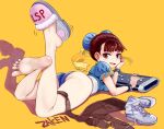  1girl :d absurdres artist_name ass bangs bare_legs barefoot blue_dress blunt_bangs blush boots bracelet breasts brown_eyes brown_hair brown_legwear bun_cover china_dress chinese_clothes chun-li clothes_removed controller double_bun dress earrings fang feet_up game_controller hair_pulled_back hair_ribbon head_rest highres jewelry looking_at_viewer looking_back lying on_stomach open_mouth pantyhose puffy_short_sleeves puffy_sleeves ribbon sash shadow shiny shiny_hair shoes short_sleeves simple_background single_shoe skin_fang slippers smile soles solo spiked_bracelet spikes street_fighter toes unitard white_footwear yellow_background zaken 