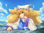  1girl animal_ears blonde_hair breasts city cloud commentary_request day dress eyebrows_visible_through_hair fox_ears fox_tail frills giant giantess hand_up hat highres large_breasts multiple_tails outdoors parted_lips pillow_hat pink_eyes short_hair sky smile solo tabard tail teston touhou upper_body white_dress yakumo_ran 
