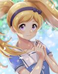  1girl bangs blonde_hair blue_shirt blurry blurry_background blush bow bow_hairband closed_mouth collarbone dappled_sunlight emily_stewart floating_hair hair_bow hairband highres highwooods idolmaster idolmaster_million_live! long_hair looking_at_viewer purple_bow purple_eyes purple_hairband shirt short_sleeves smile solo sunlight swept_bangs twintails upper_body 