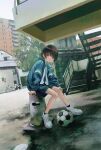  1boy ball bicycle black_hair black_legwear black_shorts blue_jacket building ground_vehicle highres jacket long_sleeves original outdoors sasakure_(mogunonbi) shadow shirt shoes short_hair shorts sitting soccer_ball socks solo stairs track_jacket white_footwear white_shirt wide_shot 