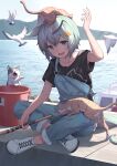  1girl :d animal_ears animal_on_head arm_up bird black_shirt blue_eyes blue_hair boat bucket cat commentary_request day flower hair_flower hair_ornament hairclip highres horse_ears horse_girl horse_tail on_head open_mouth outdoors overalls pier seagull seiun_sky_(umamusume) shirt shoes short_hair short_sleeves sitting smile solo tail umamusume water watercraft white_footwear yellow_flower yukiyama_momo 