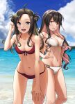 2girls ahoge ass_visible_through_thighs bare_arms bare_legs bare_shoulders bikini black_hair blush breasts cleavage collarbone day double_bun feet_out_of_frame grey_eyes groin hair_ornament hairclip highres ichikawa_feesu kantai_collection large_breasts looking_at_viewer makinami_(kancolle) multicolored_hair multiple_girls naganami_(kancolle) navel ocean open_mouth pink_hair red_bikini smile swimsuit upper_teeth white_bikini yellow_eyes 