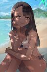  1girl absurdres beach bikini black_hair blurry blurry_background breasts brown_eyes cleavage ear_clip head_rest highres huge_filesize hugging_own_legs ijiranaide_nagatoro-san knees_to_chest light_smile long_hair looking_at_viewer nagatoro_hayase ocean piercing shizu_(shizuillust) small_breasts smile solo summer swimsuit tan tanline water 