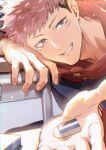  1boy black_eyes black_hair black_jacket desk eraser facial_mark grin hood hood_down hoodie itadori_yuuji jacket juju_net jujutsu_kaisen long_sleeves looking_at_viewer male_focus open_hand pink_hair red_hoodie short_hair smile solo undercut upper_body 