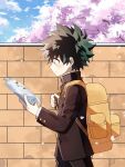  1boy backpack bag bangs black_hair black_jacket black_pants boku_no_hero_academia brick_wall cherry_blossoms cloud coi_mha commentary day freckles from_side green_hair hands_up holding jacket long_sleeves male_focus midoriya_izuku notebook orange_bag outdoors pants profile reading school_uniform sky smile solo 