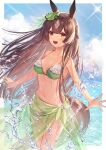  1girl animal_ears bikini blue_sky breasts brown_eyes brown_hair cloud day ear_ribbon eyebrows_visible_through_hair frilled_bikini frills green_bikini green_ribbon highres horse_ears horse_girl horse_tail long_hair ocean open_mouth partially_submerged ribbon sarong satono_diamond_(umamusume) sky smile solo standing swimsuit tail tsunakawa twitter_username umamusume wet 